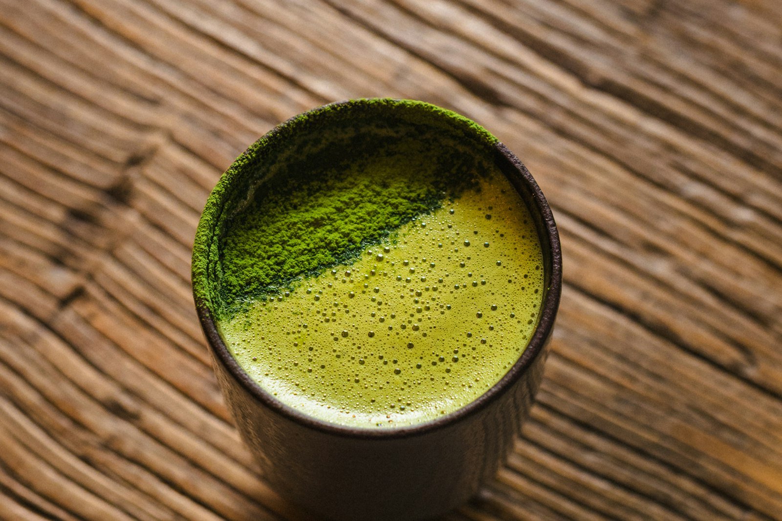 Tangan mengocok matcha dengan chasen bambu